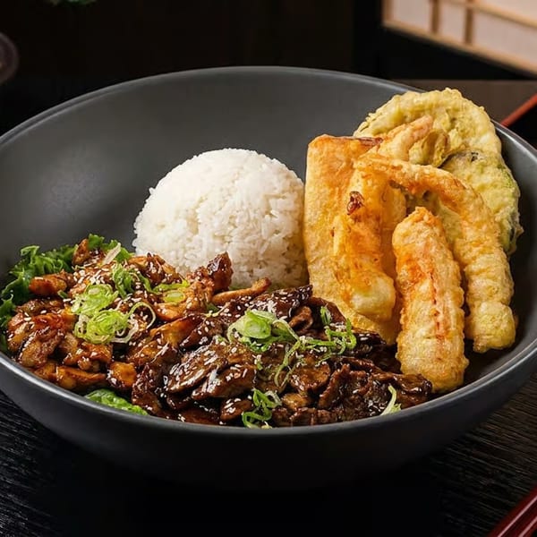 A dark bowl of Japanese food with rice, beef, lettuce, and tempura shrimp on a black tray.
